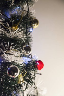 Christmas ornaments. With copy space and neutral background. Green Christmas tree with red and gold and silver ornaments. Year-end party concept. New year concept. Christmas lights.	