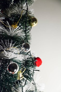 Christmas ornaments. With copy space and neutral background. Green Christmas tree with red and gold and silver ornaments. Year-end party concept. New year concept. Christmas lights.	