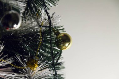 Christmas ornaments. With copy space and neutral background. Green Christmas tree with red and gold and silver ornaments. Year-end party concept. New year concept. Christmas lights.	