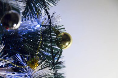 Christmas ornaments. With copy space and neutral background. Green Christmas tree with red and gold and silver ornaments. Year-end party concept. New year concept. Christmas lights.	