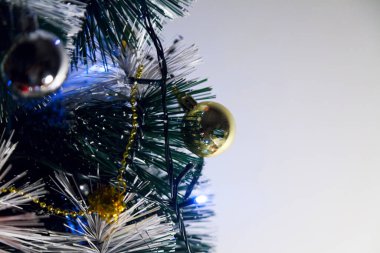 Christmas ornaments. With copy space and neutral background. Green Christmas tree with red and gold and silver ornaments. Year-end party concept. New year concept. Christmas lights.	