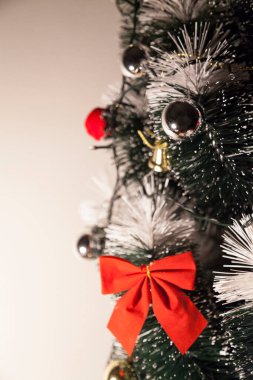 Noel ağacını kırmızı halkayla süslemek güzel ve uyumlu bir ortam yaratıyor. Hristiyan kültürünün mutluluk getiren şenliği ve geleneği. Noel konsepti. Uzayı kopyala Selam ver.