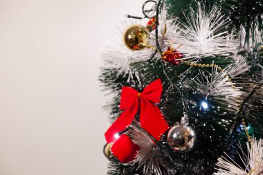 Noel ağacını kırmızı halkayla süslemek güzel ve uyumlu bir ortam yaratıyor. Hristiyan kültürünün mutluluk getiren şenliği ve geleneği. Noel konsepti. Uzayı kopyala Selam ver.