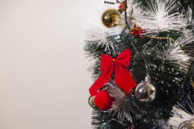 Noel ağacını kırmızı halkayla süslemek güzel ve uyumlu bir ortam yaratıyor. Hristiyan kültürünün mutluluk getiren şenliği ve geleneği. Noel konsepti. Uzayı kopyala Selam ver.