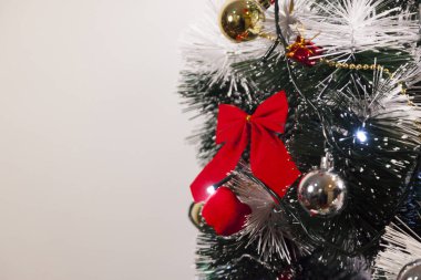 Noel ağacını kırmızı halkayla süslemek güzel ve uyumlu bir ortam yaratıyor. Hristiyan kültürünün mutluluk getiren şenliği ve geleneği. Noel konsepti. Uzayı kopyala Selam ver.