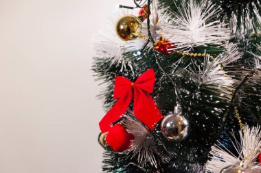 Noel ağacını kırmızı halkayla süslemek güzel ve uyumlu bir ortam yaratıyor. Hristiyan kültürünün mutluluk getiren şenliği ve geleneği. Noel konsepti. Uzayı kopyala Selam ver.