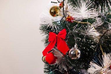 Noel ağacını kırmızı halkayla süslemek güzel ve uyumlu bir ortam yaratıyor. Hristiyan kültürünün mutluluk getiren şenliği ve geleneği. Noel konsepti. Uzayı kopyala Selam ver.