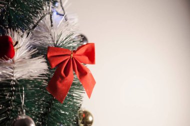 Noel ağacını kırmızı halkayla süslemek güzel ve uyumlu bir ortam yaratıyor. Hristiyan kültürünün mutluluk getiren şenliği ve geleneği. Noel konsepti. Uzayı kopyala Selam ver.