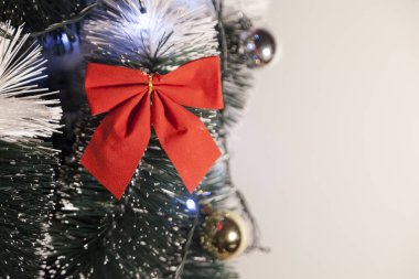 Noel ağacını kırmızı halkayla süslemek güzel ve uyumlu bir ortam yaratıyor. Hristiyan kültürünün mutluluk getiren şenliği ve geleneği. Noel konsepti. Uzayı kopyala Selam ver.