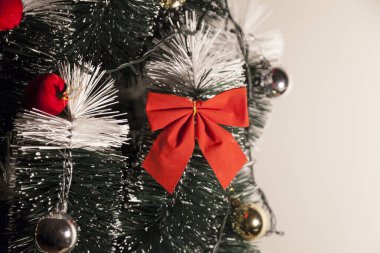 Noel ağacını kırmızı halkayla süslemek güzel ve uyumlu bir ortam yaratıyor. Hristiyan kültürünün mutluluk getiren şenliği ve geleneği. Noel konsepti. Uzayı kopyala Selam ver.