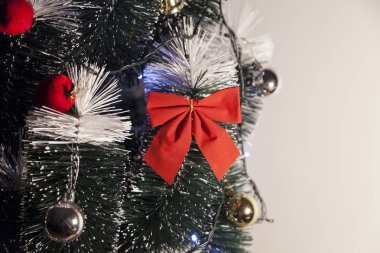 Noel ağacını kırmızı halkayla süslemek güzel ve uyumlu bir ortam yaratıyor. Hristiyan kültürünün mutluluk getiren şenliği ve geleneği. Noel konsepti. Uzayı kopyala Selam ver.