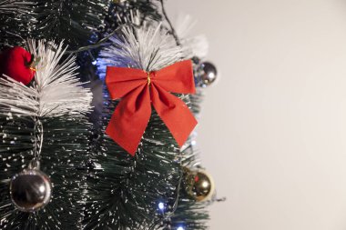 Noel ağacını kırmızı halkayla süslemek güzel ve uyumlu bir ortam yaratıyor. Hristiyan kültürünün mutluluk getiren şenliği ve geleneği. Noel konsepti. Uzayı kopyala Selam ver.