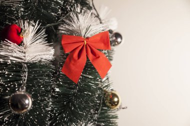 Noel ağacını kırmızı halkayla süslemek güzel ve uyumlu bir ortam yaratıyor. Hristiyan kültürünün mutluluk getiren şenliği ve geleneği. Noel konsepti. Uzayı kopyala Selam ver.