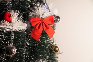 Noel ağacını kırmızı halkayla süslemek güzel ve uyumlu bir ortam yaratıyor. Hristiyan kültürünün mutluluk getiren şenliği ve geleneği. Noel konsepti. Uzayı kopyala Selam ver.