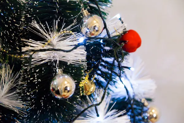 Christmas ornaments. With copy space and neutral background. Green Christmas tree with red and gold and silver ornaments. Year-end party concept. New year concept. Christmas lights.	