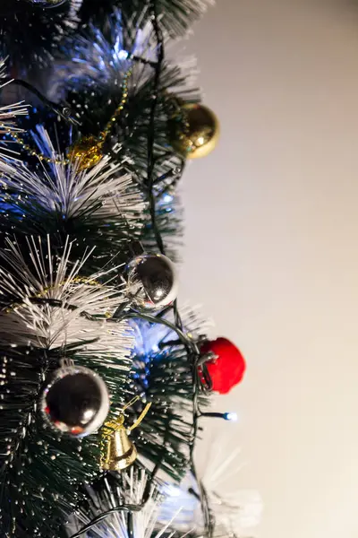 Christmas ornaments. With copy space and neutral background. Green Christmas tree with red and gold and silver ornaments. Year-end party concept. New year concept. Christmas lights.	