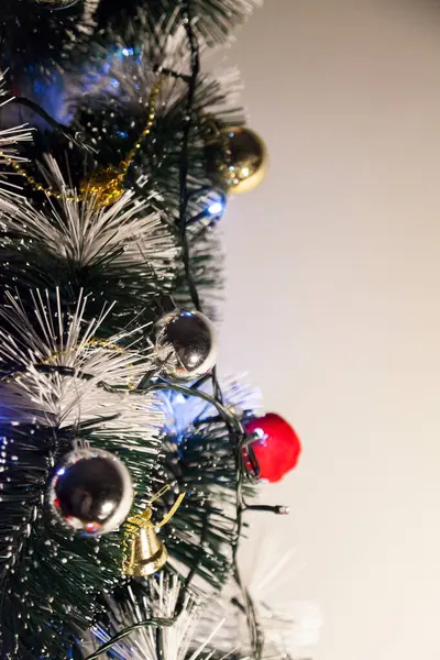 Christmas ornaments. With copy space and neutral background. Green Christmas tree with red and gold and silver ornaments. Year-end party concept. New year concept. Christmas lights.	