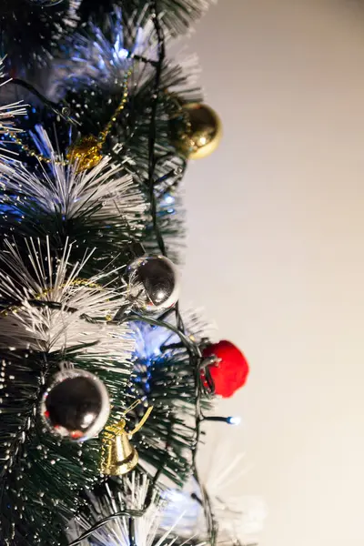 Christmas ornaments. With copy space and neutral background. Green Christmas tree with red and gold and silver ornaments. Year-end party concept. New year concept. Christmas lights.	