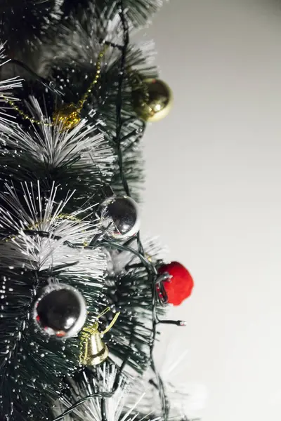 Christmas ornaments. With copy space and neutral background. Green Christmas tree with red and gold and silver ornaments. Year-end party concept. New year concept. Christmas lights.	