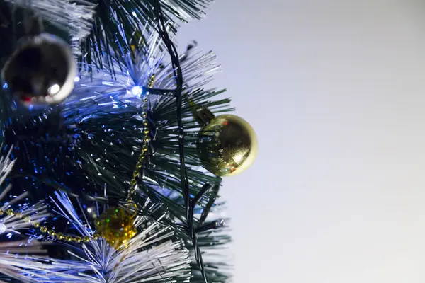 Christmas ornaments. With copy space and neutral background. Green Christmas tree with red and gold and silver ornaments. Year-end party concept. New year concept. Christmas lights.	