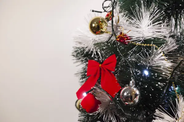 Noel ağacını kırmızı halkayla süslemek güzel ve uyumlu bir ortam yaratıyor. Hristiyan kültürünün mutluluk getiren şenliği ve geleneği. Noel konsepti. Uzayı kopyala Selam ver.