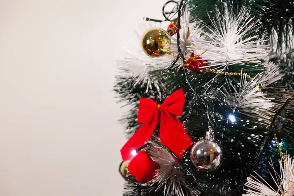 Noel ağacını kırmızı halkayla süslemek güzel ve uyumlu bir ortam yaratıyor. Hristiyan kültürünün mutluluk getiren şenliği ve geleneği. Noel konsepti. Uzayı kopyala Selam ver.