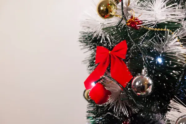 Noel ağacını kırmızı halkayla süslemek güzel ve uyumlu bir ortam yaratıyor. Hristiyan kültürünün mutluluk getiren şenliği ve geleneği. Noel konsepti. Uzayı kopyala Selam ver.