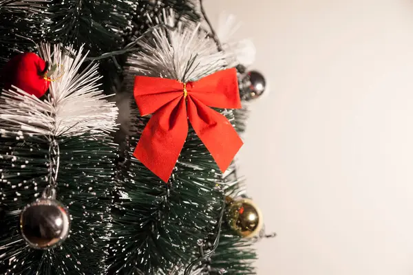 Noel ağacını kırmızı halkayla süslemek güzel ve uyumlu bir ortam yaratıyor. Hristiyan kültürünün mutluluk getiren şenliği ve geleneği. Noel konsepti. Uzayı kopyala Selam ver.