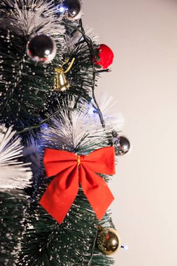 Noel ağacını kırmızı halkayla süslemek güzel ve uyumlu bir ortam yaratıyor. Hristiyan kültürünün mutluluk getiren şenliği ve geleneği. Noel konsepti. Uzayı kopyala Selam ver.