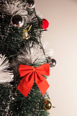 Noel ağacını kırmızı halkayla süslemek güzel ve uyumlu bir ortam yaratıyor. Hristiyan kültürünün mutluluk getiren şenliği ve geleneği. Noel konsepti. Uzayı kopyala Selam ver.