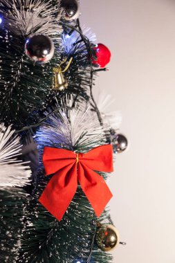 Noel ağacını kırmızı halkayla süslemek güzel ve uyumlu bir ortam yaratıyor. Hristiyan kültürünün mutluluk getiren şenliği ve geleneği. Noel konsepti. Uzayı kopyala Selam ver.