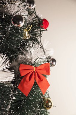 Noel ağacını kırmızı halkayla süslemek güzel ve uyumlu bir ortam yaratıyor. Hristiyan kültürünün mutluluk getiren şenliği ve geleneği. Noel konsepti. Uzayı kopyala Selam ver.