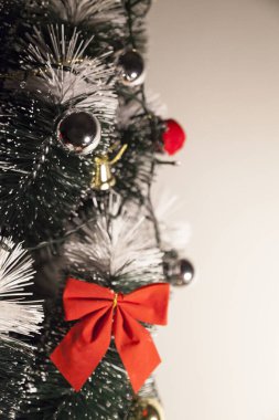 Noel ağacını kırmızı halkayla süslemek güzel ve uyumlu bir ortam yaratıyor. Hristiyan kültürünün mutluluk getiren şenliği ve geleneği. Noel konsepti. Uzayı kopyala Selam ver.