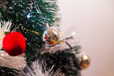 Close-up of balls on the Christmas tree with neutral background. Brazilian Christmas. Tree decoration. New year concept. Tree concept.	