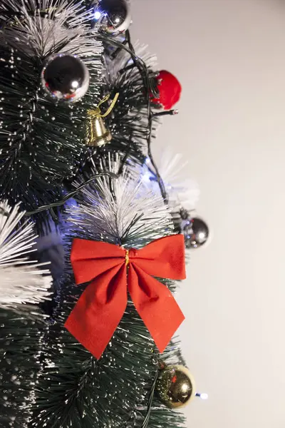 Noel ağacını kırmızı halkayla süslemek güzel ve uyumlu bir ortam yaratıyor. Hristiyan kültürünün mutluluk getiren şenliği ve geleneği. Noel konsepti. Uzayı kopyala Selam ver.