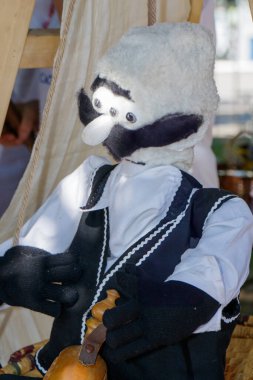 Geleneksel giyinmiş bir kukla, canlı bir açık hava festivalinde sergileniyor..