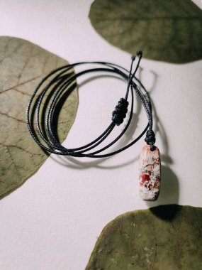 Doğal iğne şekli pembe Jasper iyileştirme kristali ayarlanabilir siyah kordon küçük taş kolye, enerji mücevheri beyaz arka planda minimalist kolye Jasper yapraklarla kaplanmış el yapımı mücevherler. 