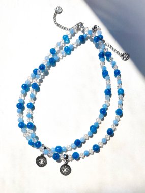 Bir çift mavi taştan apatit boncuklu göz alıcısı düz bir üst görünüm yatıyordu. Doğal değerli taş mücevherler, aksesuarlar, moda koleksiyonu, el işleri, mücevherler.