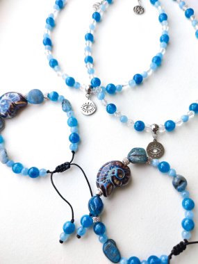 Mavi taş kyanit apatit boncuklu bilezikler ve göz alıcılarıyla düz bir üst görüş yatıyordu. Doğal değerli taş mücevherler, aksesuarlar, moda koleksiyonu, el işleri, mücevherler.