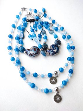 Mavi taş akuamarin apatit kyanit boncuklu mücevher düz yakın yatıyordu. Göz tılsımlı kolyeler, bilezikler. Doğal değerli taş mücevherler, aksesuarlar, moda koleksiyonu, el işleri, mücevher.