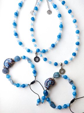 Mavi taş kyanit apatit boncuklu bilezikler ve göz alıcılarıyla düz bir üst görüş yatıyordu. Doğal değerli taş mücevherler, aksesuarlar, moda koleksiyonu, el işleri, mücevherler.