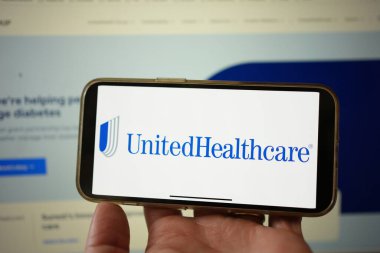 Roosendaal, Hollanda - 3 Şubat 2025: Sağlık hizmetleri ve sigorta hizmeti sağlayan bir şirket olan Birleşik Sağlık Hizmetleri logosunu gösteren bir cep telefonu ekranı. Arkaplanda web sitesi.