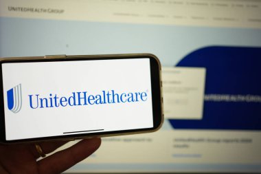 Roosendaal, Hollanda - 3 Şubat 2025: Sağlık hizmetleri ve sigorta hizmeti sağlayan bir şirket olan Birleşik Sağlık Hizmetleri logosunu gösteren bir cep telefonu ekranı. Arkaplanda web sitesi.