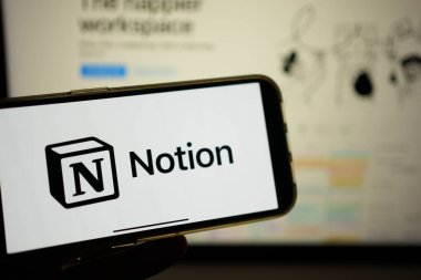 Roosendaal, The Netherlands - February 2, 2025: A mobile phone screen displaying the logo of Notion, an all-in-one customizable project management app, with the company website in the background. clipart