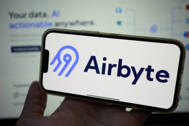 Roosendaal, The Netherlands - February 2, 2025: Person holding a mobile phone displaying the logo of Airbyte, an open-source data integration platform. clipart