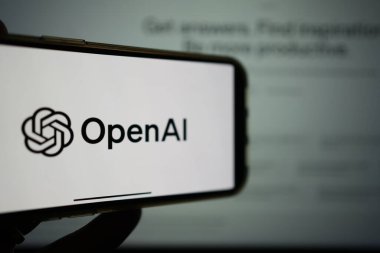 Roosendaal, Hollanda - 10 Şubat 2025: Arka planda ChatGPT logosu olan OpenAI logosunu gösteren bir cep telefonu.