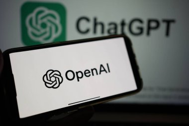 Roosendaal, Hollanda - 10 Şubat 2025: Arka planda ChatGPT logosu olan OpenAI logosunu gösteren bir cep telefonu.