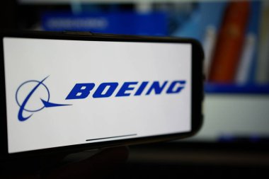 Roosendaal, Hollanda - 10 Şubat 2025: Boeing logosunu gösteren bir cep telefonu, arka planda şirket havacılık web sitesi.