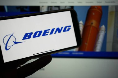 Roosendaal, Hollanda - 10 Şubat 2025: Boeing logosunu gösteren bir cep telefonu, arka planda şirket havacılık web sitesi.