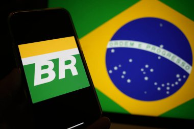 Roosendaal, The Netherlands - February 13, 2025: A mobile phone displaying the logo of Petrobras; with the flag of Brazil in the background. clipart